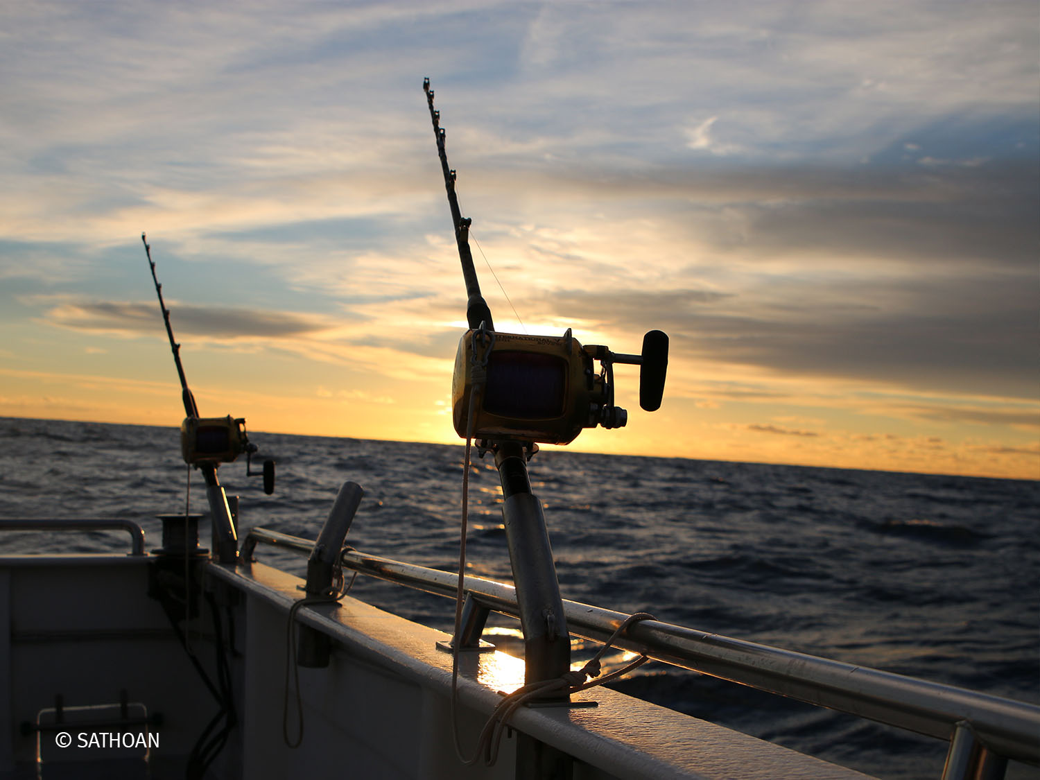 canne à pêche à l'eau et coucher de soleil