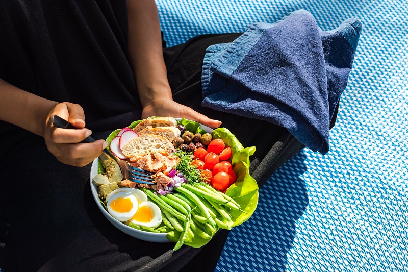 Person holding a bowl of salmon salad