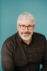 Headshot of Dan Averill on a blue background