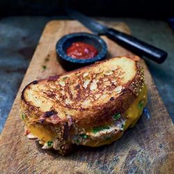 Tuna melt served on a board with ketchup